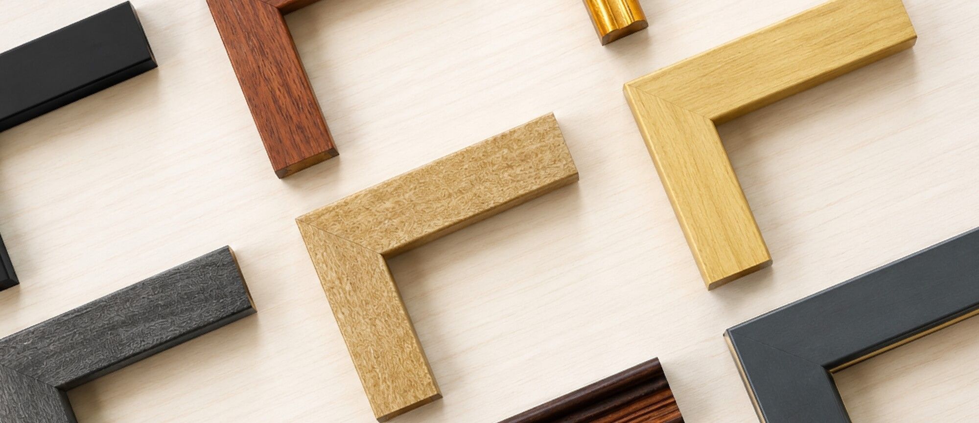 Various picture frames in different colors and materials arranged on a surface.