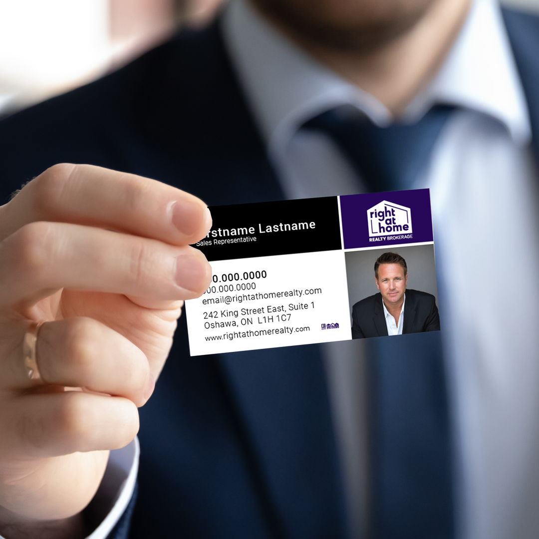 Business professional holding a custom Right At Home Realty business card printed by New Era Print Solutions.