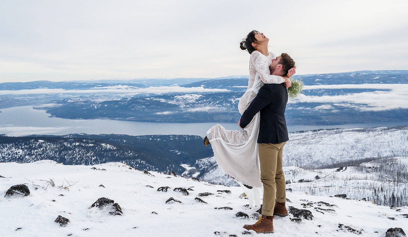 Bride wearing long sleeve lace and groom on top of a mountain in the Canadian Alps