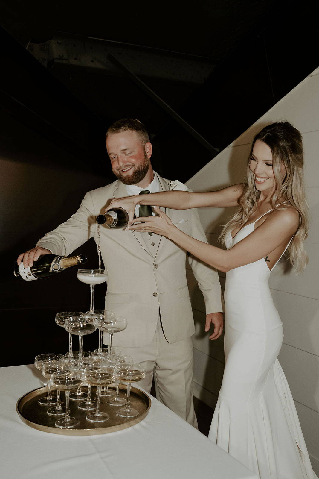 GRACE Bride Gabbie and husband Garret pouring champagne