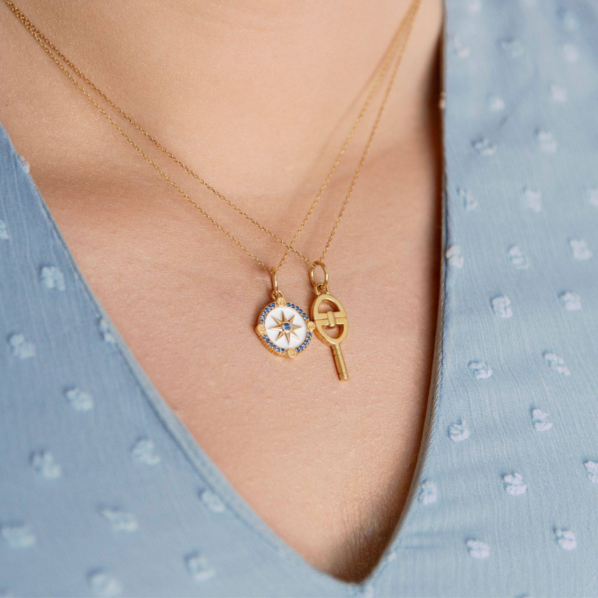 WOMAN WEARING TWO YELLOW GOLD CHARM NECKLACES