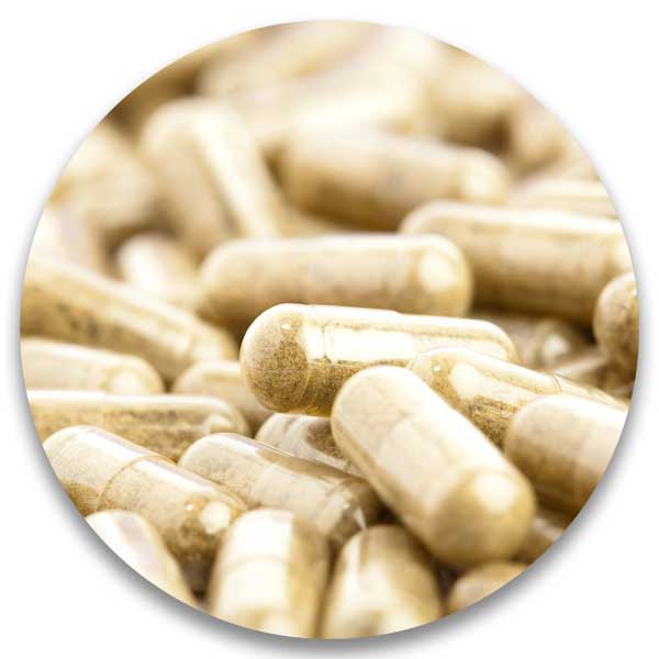 Close-up of numerous beige dietary capsules piled together.