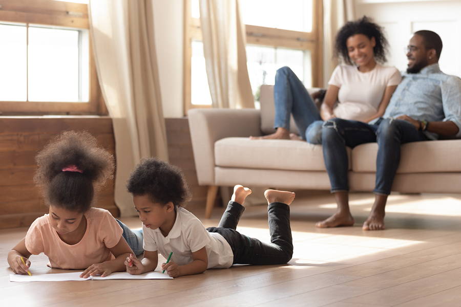 kids coloring with parents watching in background