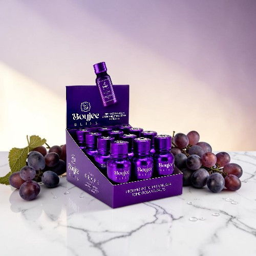 Display of purple serum bottles with grapes on a marble surface.