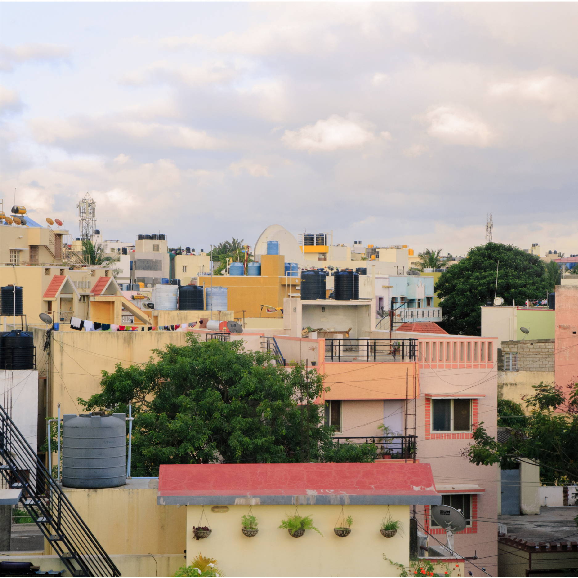 The sun sets across a crowded and colorful Indian neighborhood in Bangalore India. 