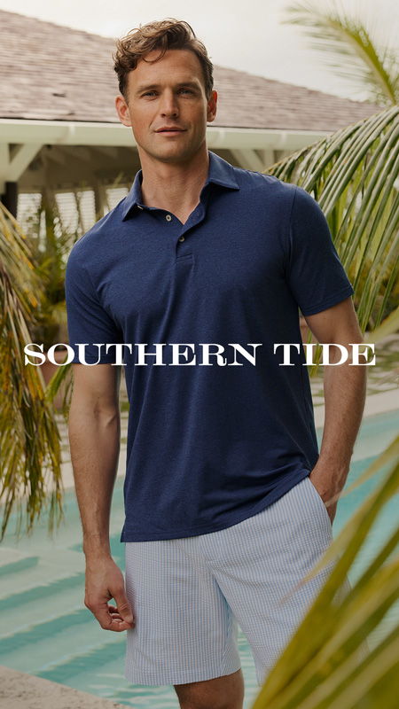 A man in a blue polo shirt stands by a pool.
