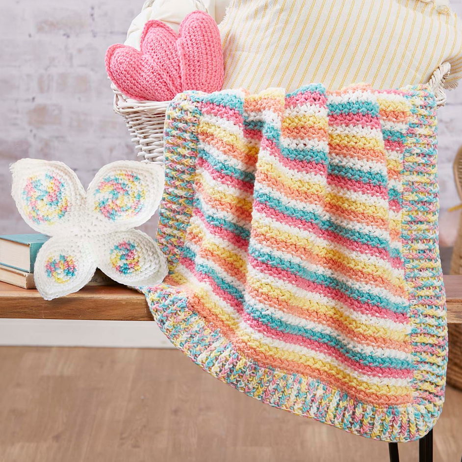 Colorful blanket draped over a chair with decorative pillows.