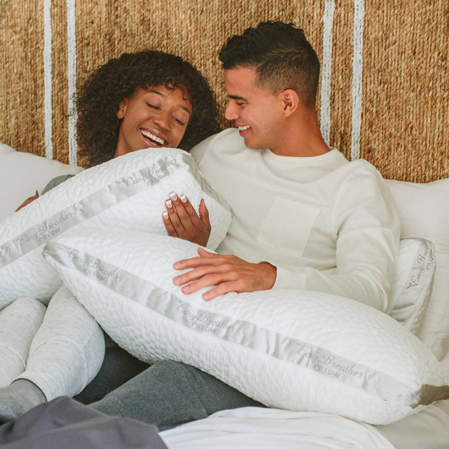 Man and woman holding pillows