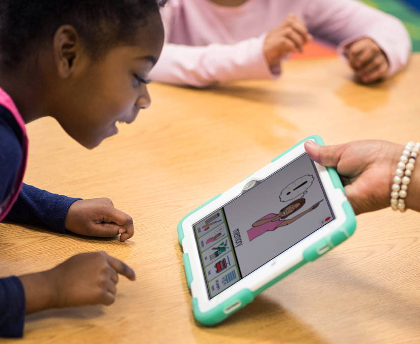 Fille utilisant un iPad doté de pictogrammes PCS Tobii Dynavox 