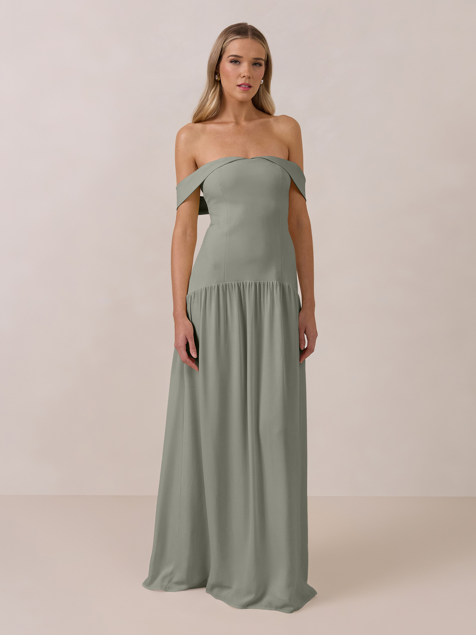Woman wearing a long, off-the-shoulder, green dress.