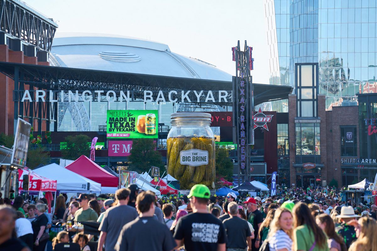 The Big Brine, a 25 foot inflatable pickle jar, towering over the crowd at The Big Dill pickle festival at Texas Live! in Arlington Texas