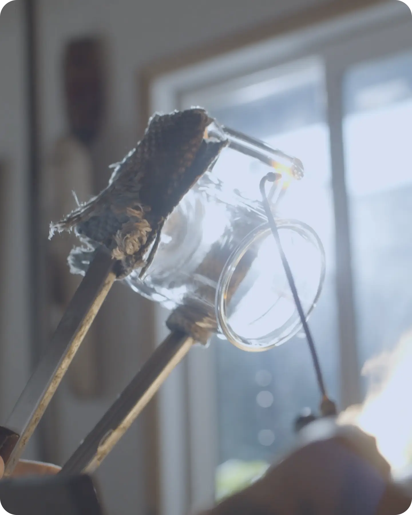 A glass artisan shaping a Pure Over brewer in the flame