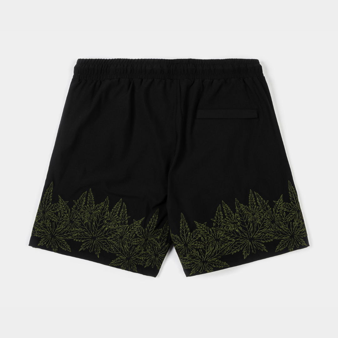 Black swim shorts with green leaf design and 