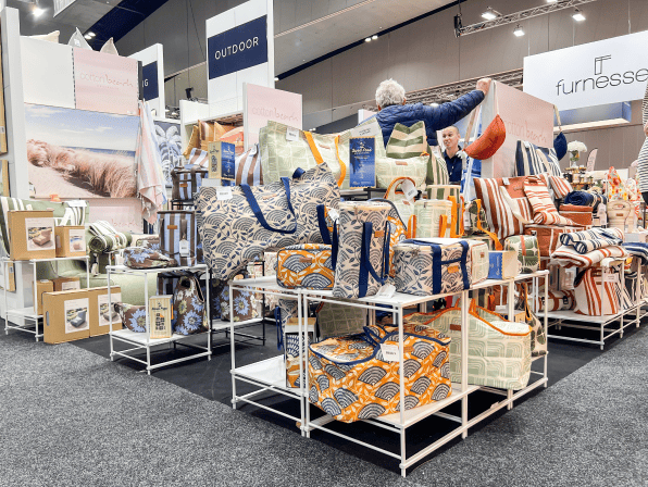 A display of various bags and home goods at a trade show.