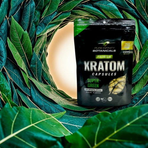 Kratom capsules package surrounded by green leaves.