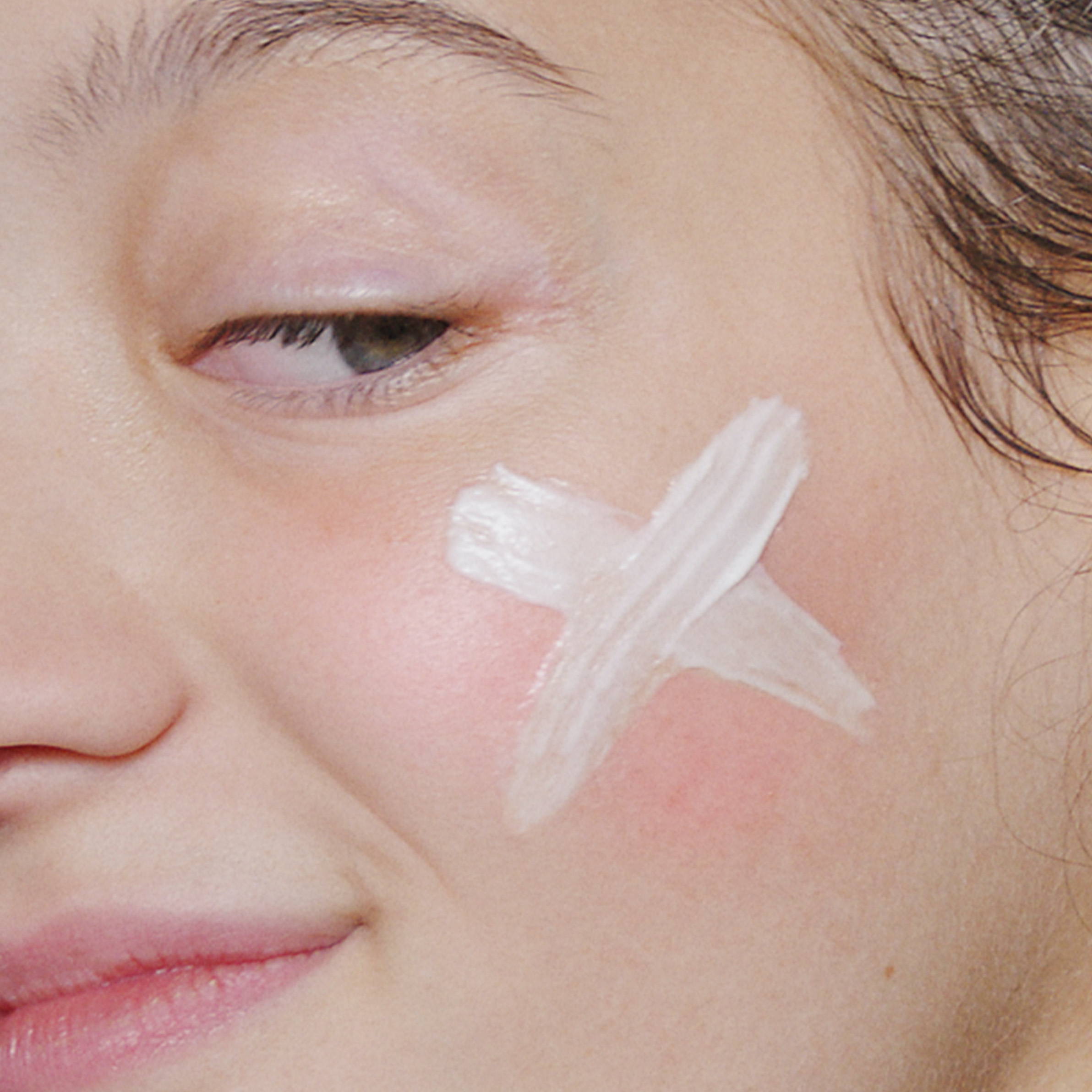 Model with Stabilizing Repair Cream on cheek