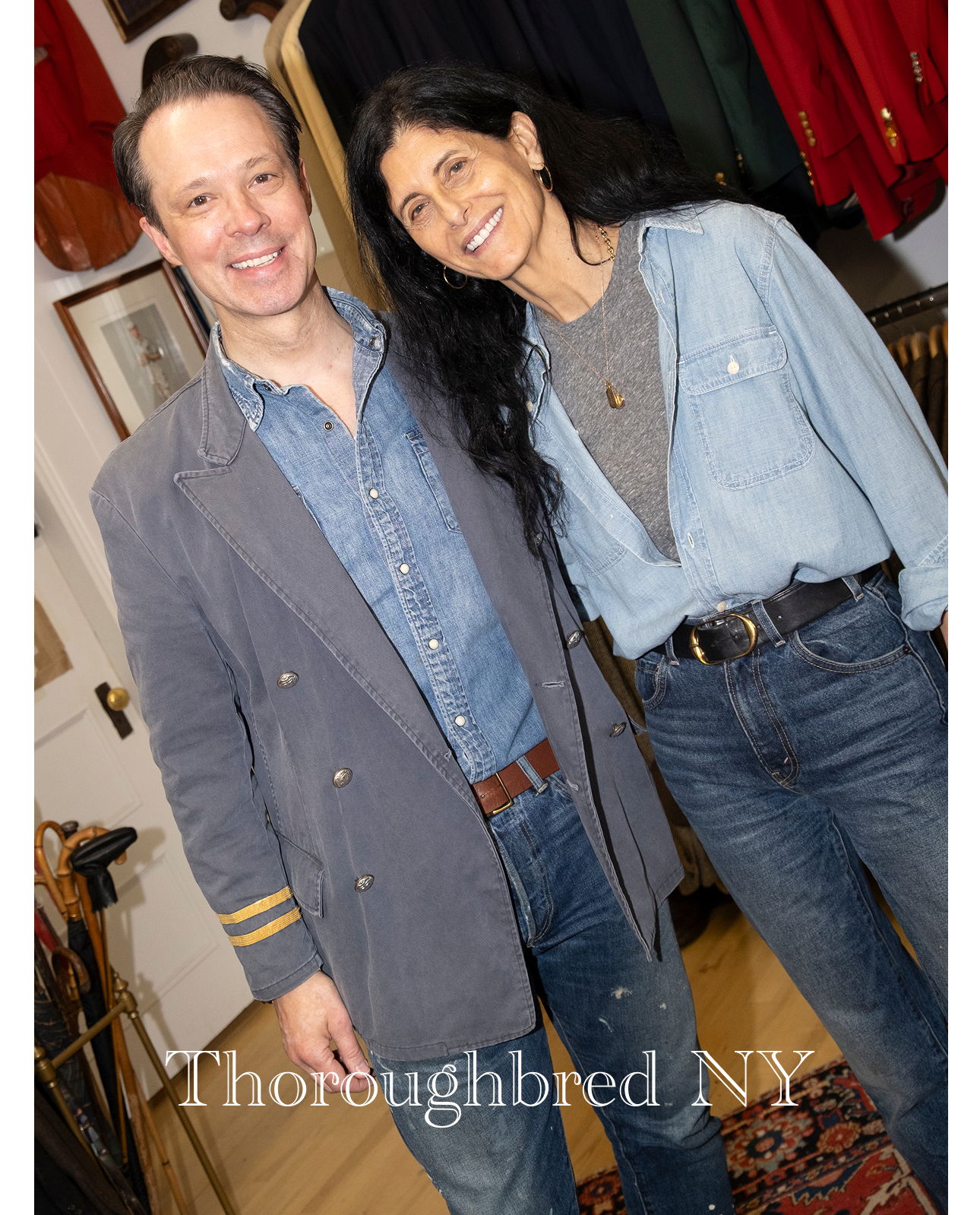 Two smiling people wearing denim outfits in a boutique setting.