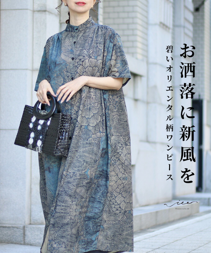 A person in a stylish patterned dress holding a handbag.