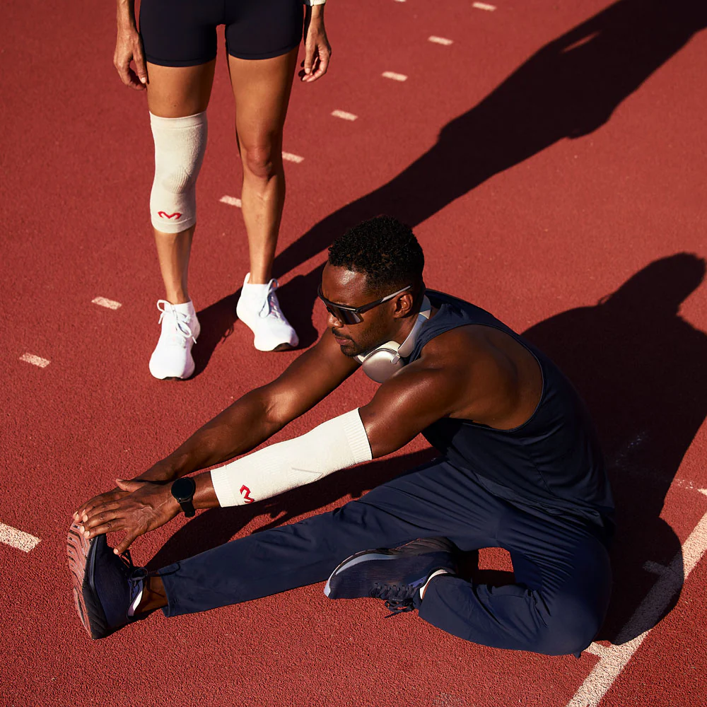 Athletes stretching on a running track, preparing for exercise.