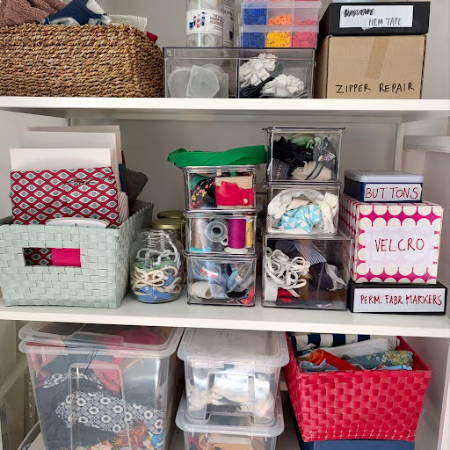 Open shelves with baskets and boxes holding sewing supplies