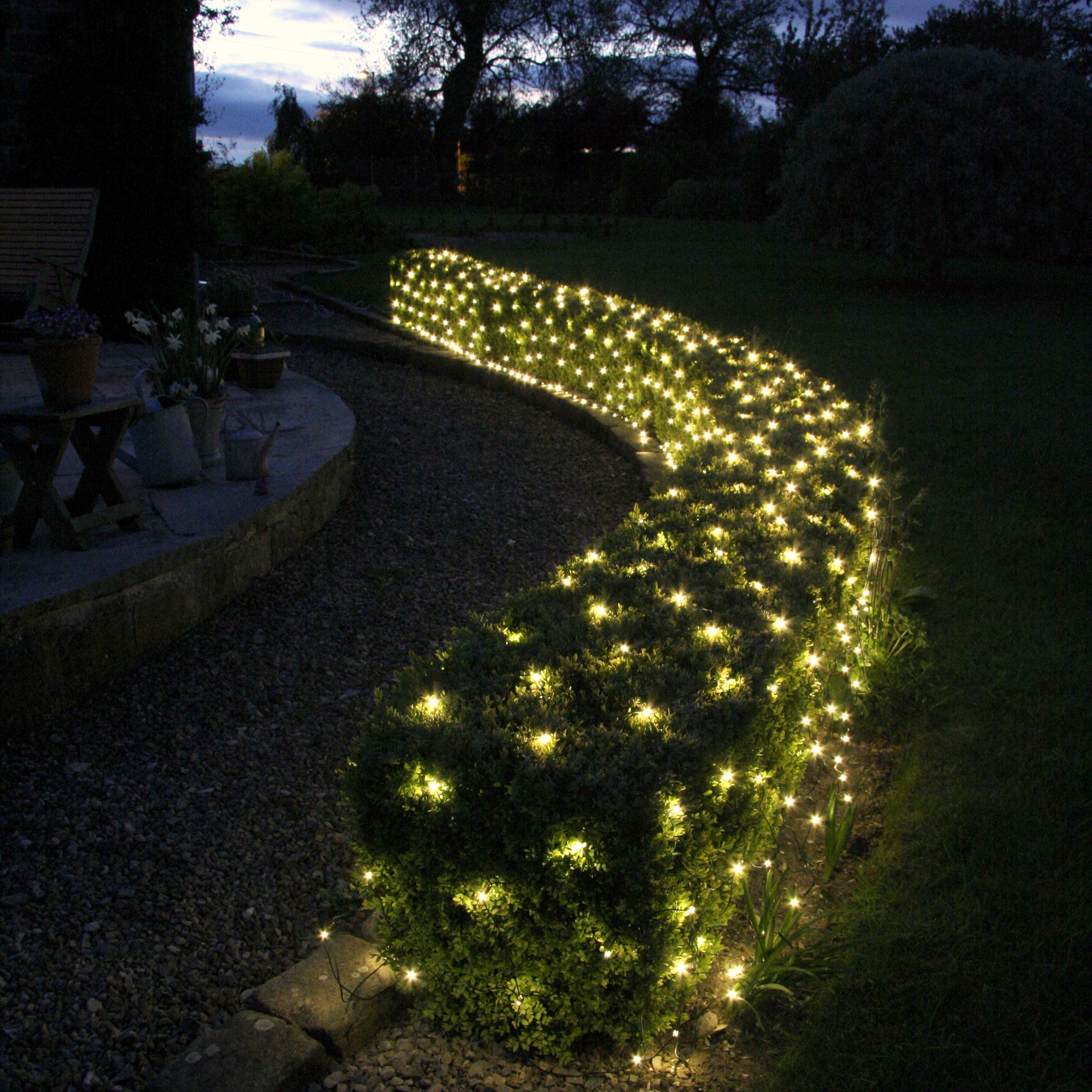 Warm white outdoor battery net lights in a Christmas garden