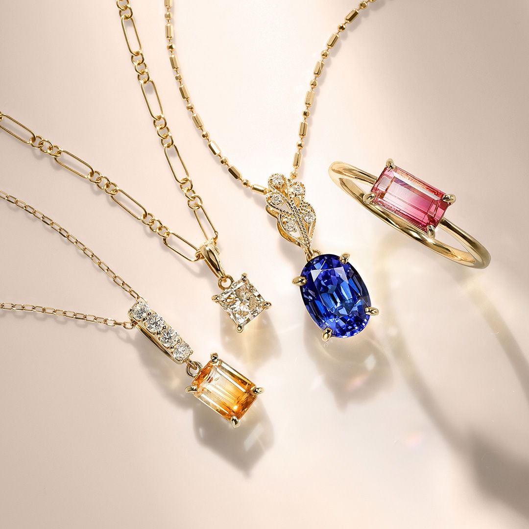 Various gold necklaces and rings with colorful gemstones.