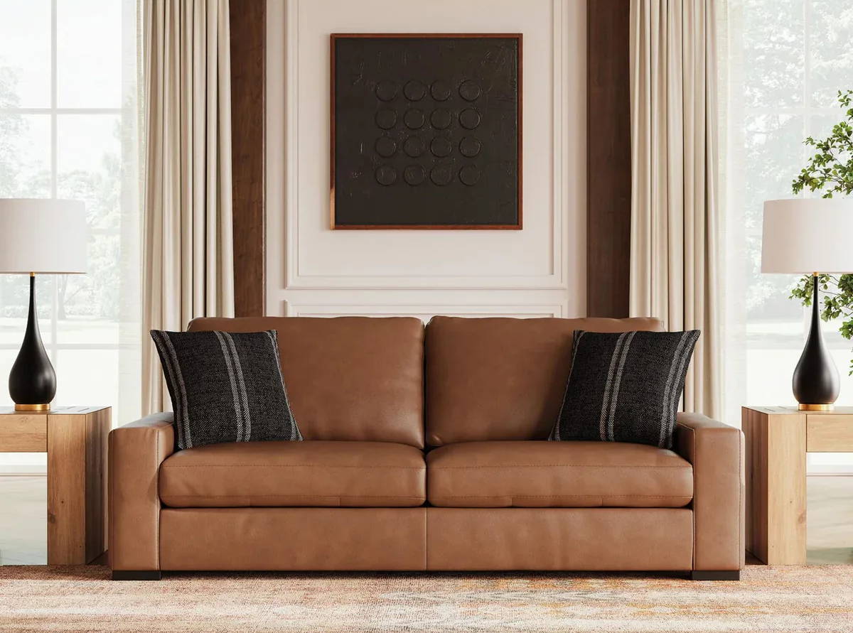 Brown leather sofa with decorative pillows and curtains in a bright room.