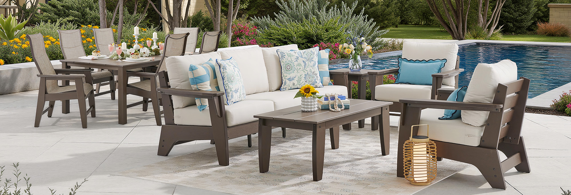 Outdoor seating area with furniture near a swimming pool.