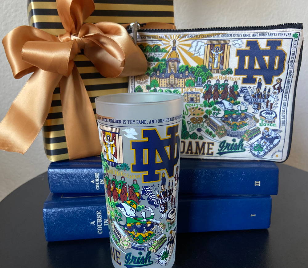 Notre Dame glass and zip pouch with gold wrapped gift and books