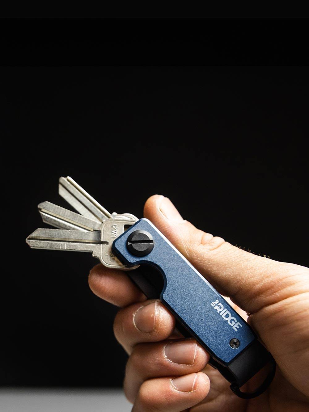 holding a Ridge Alpine Navy keycase