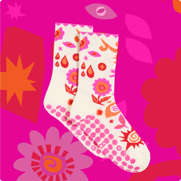 Colorful patterned socks on a bright pink background with floral designs.