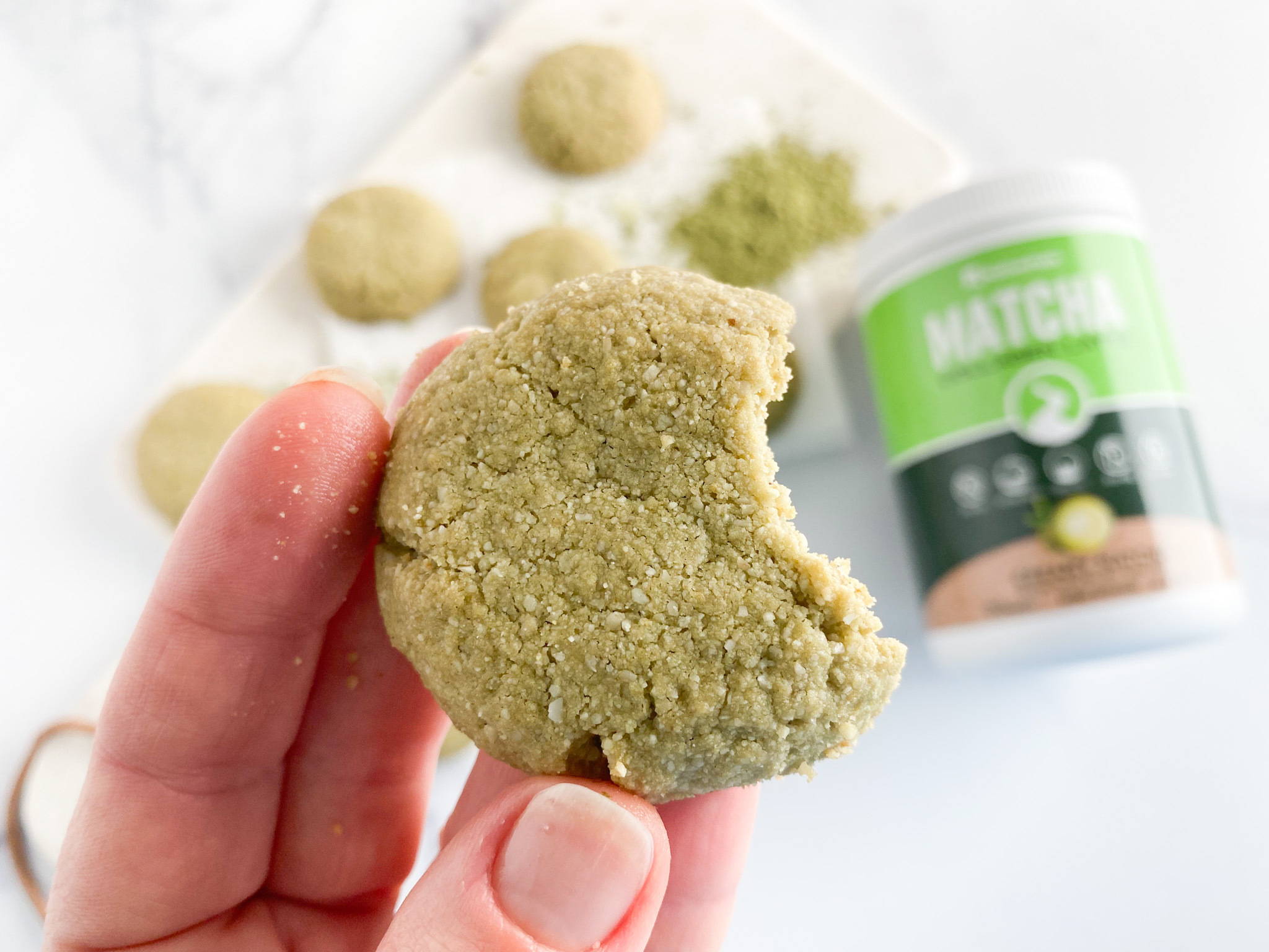 Woman holding a paleo matcha green tea cookie. 