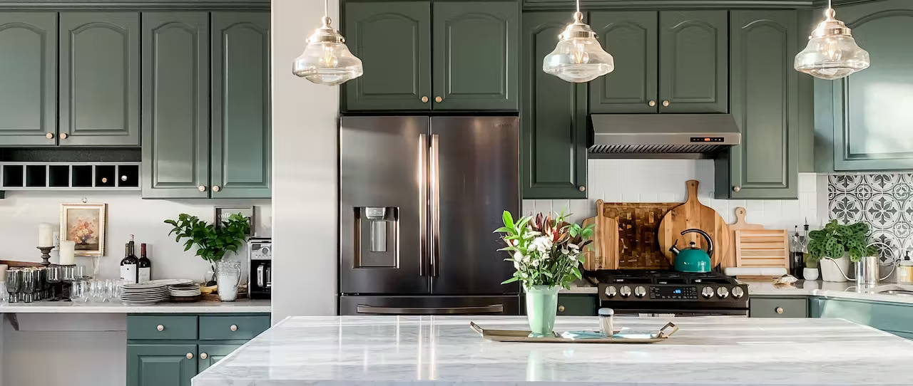 Kitchen with painted green cabinets and dark appliances