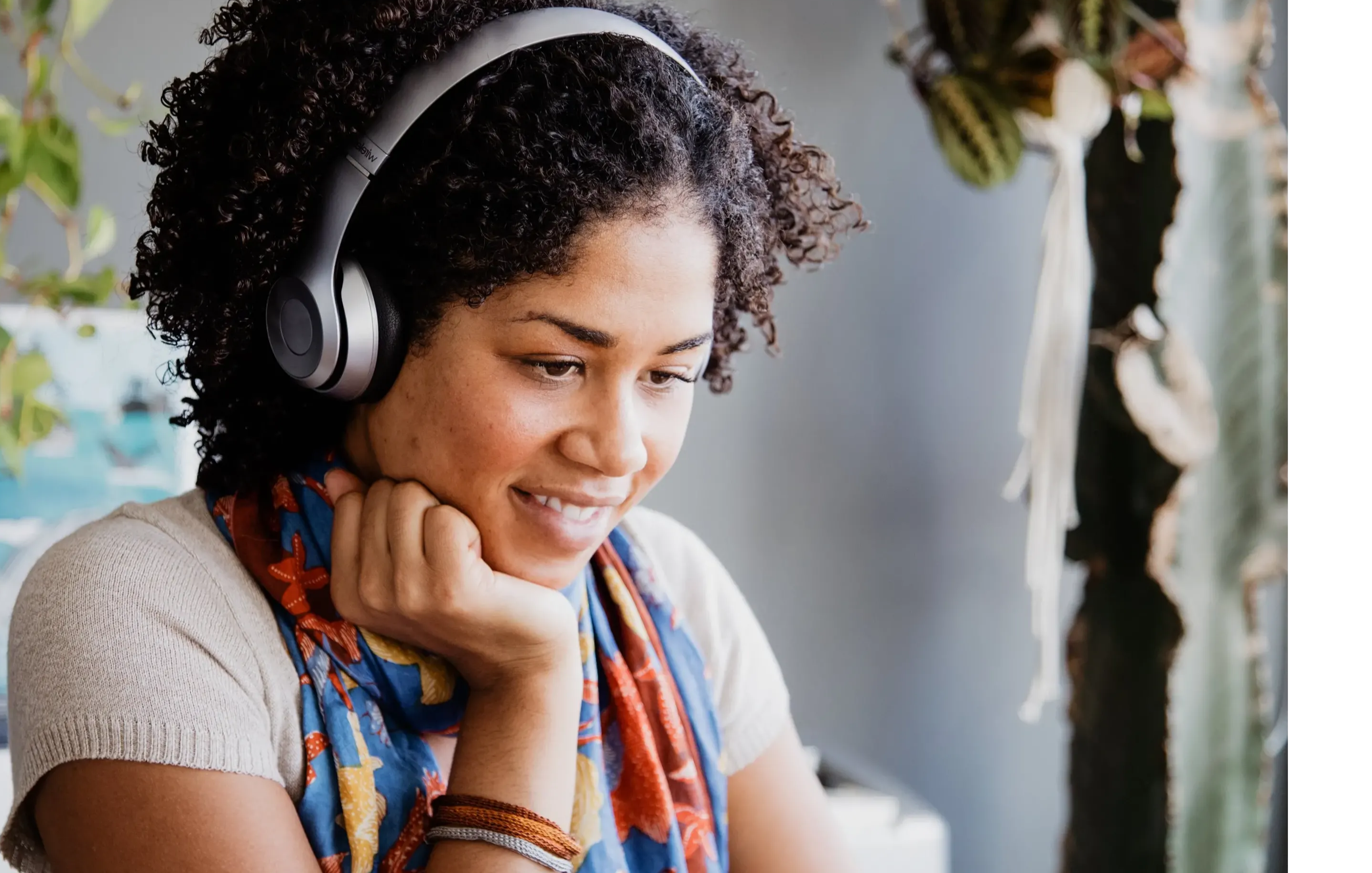 Black woman looking at a computer with headphones off