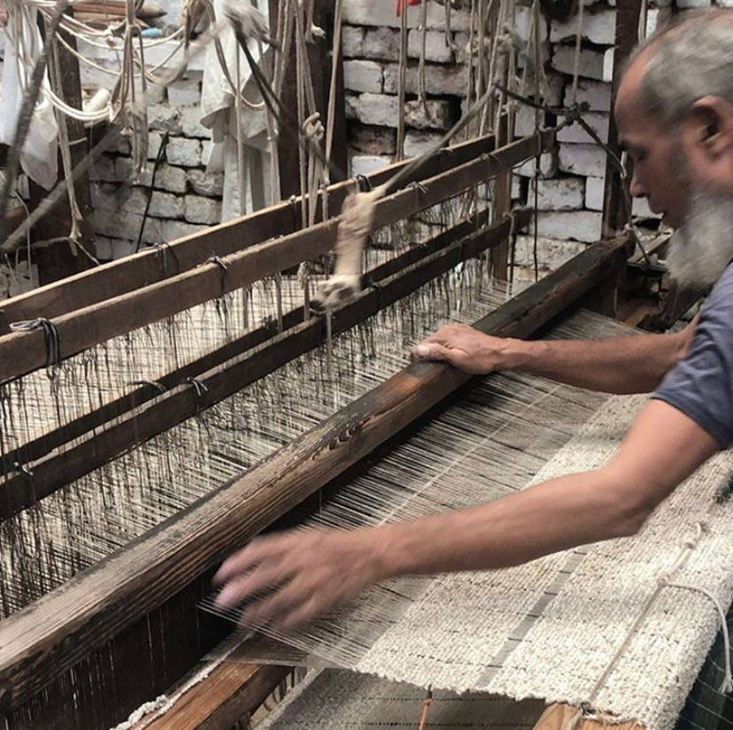 Artisan using the traditional technique of hand looming in India