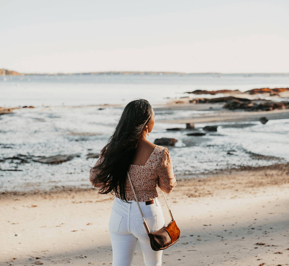 woman on the beach wearing a leather crossbody