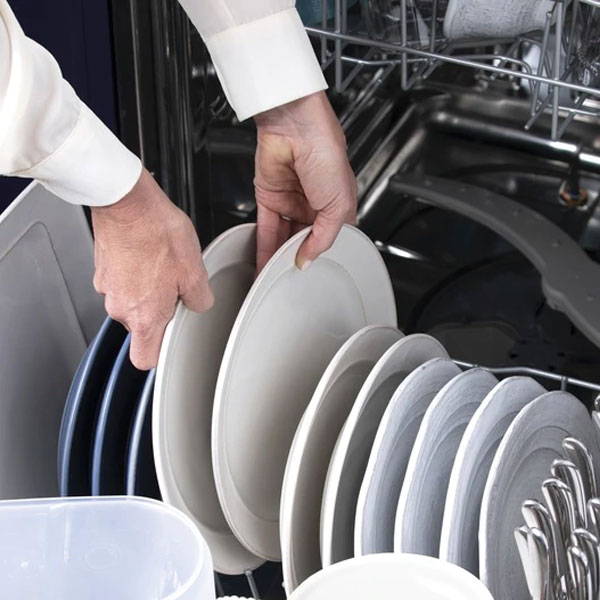 woman loading plates into a GE Appliances dishwasher