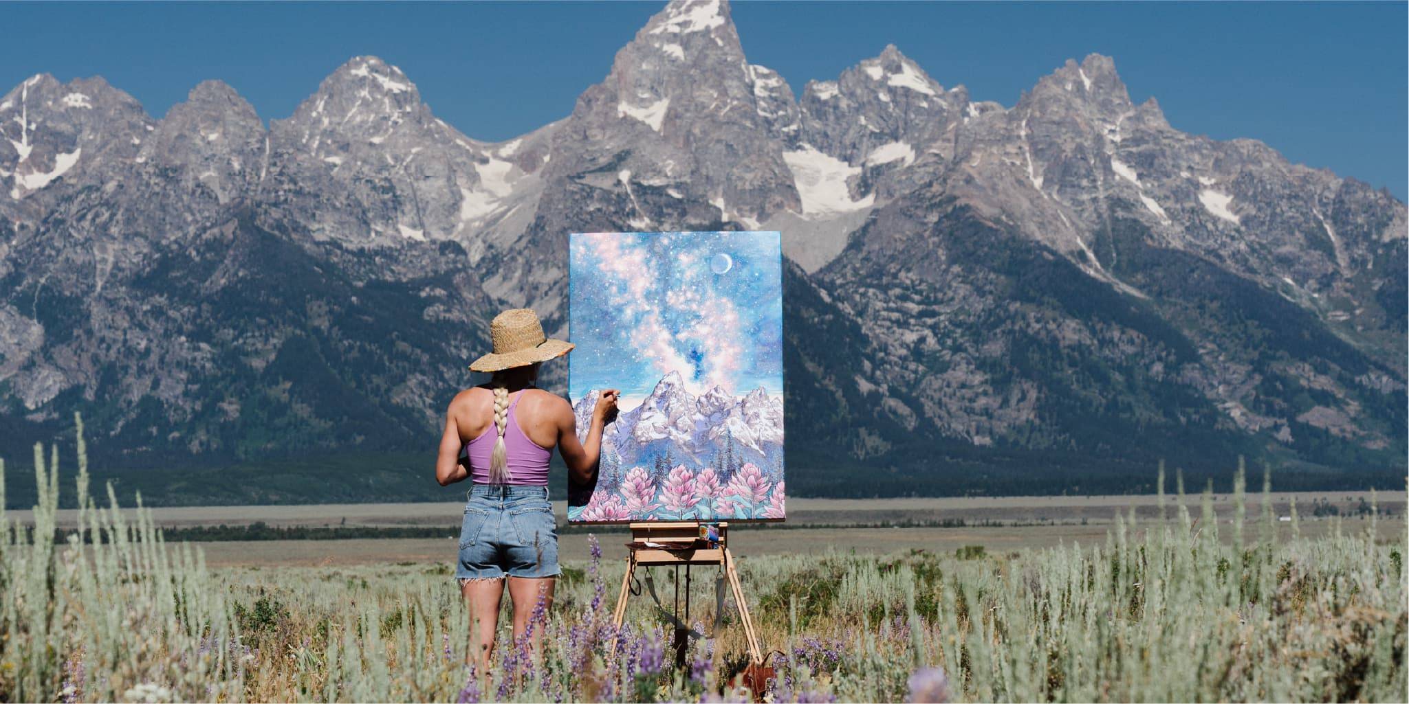 Rachel Pohl painting on a canvas in front of the teton mountains