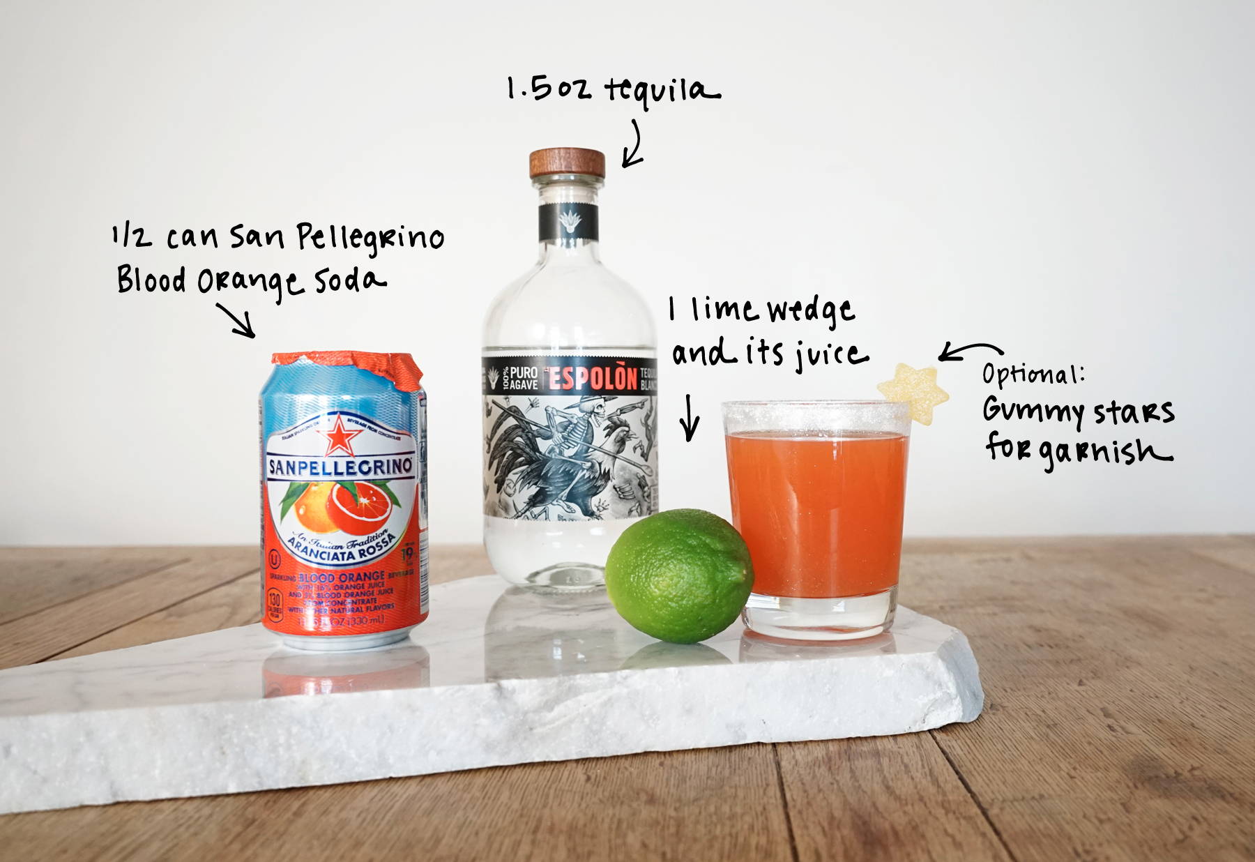 Unicorn Snot Spritz recipe with espolon tequila, san pellegrino blood orange soda, lime juice and dylan's candy bar gummies.