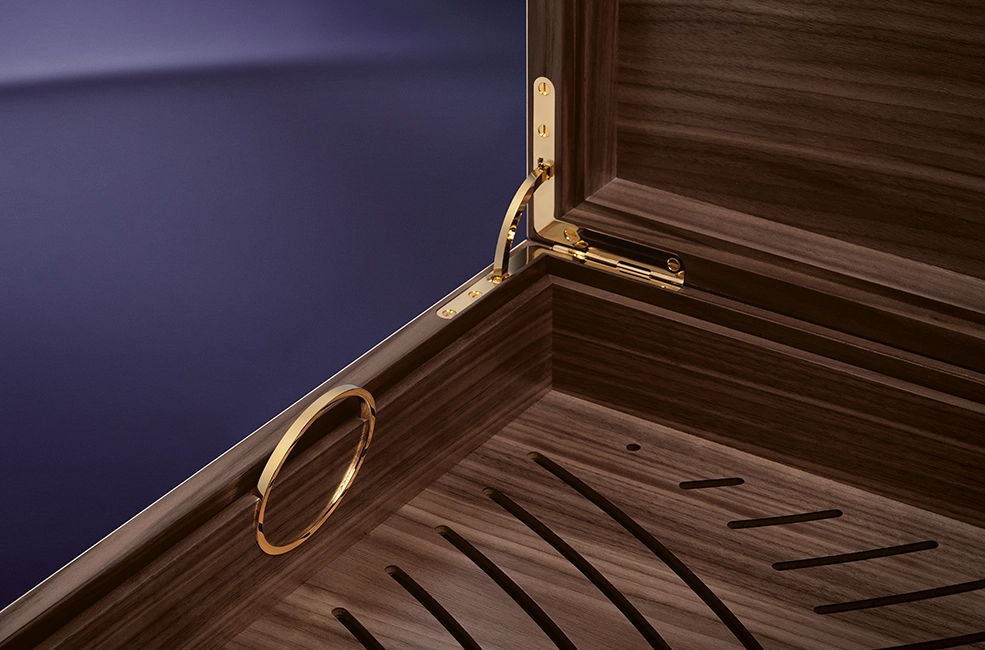Der herausnehmbare Korb mit goldenen Griffen im Inneren des Masterpiece-Humidors.