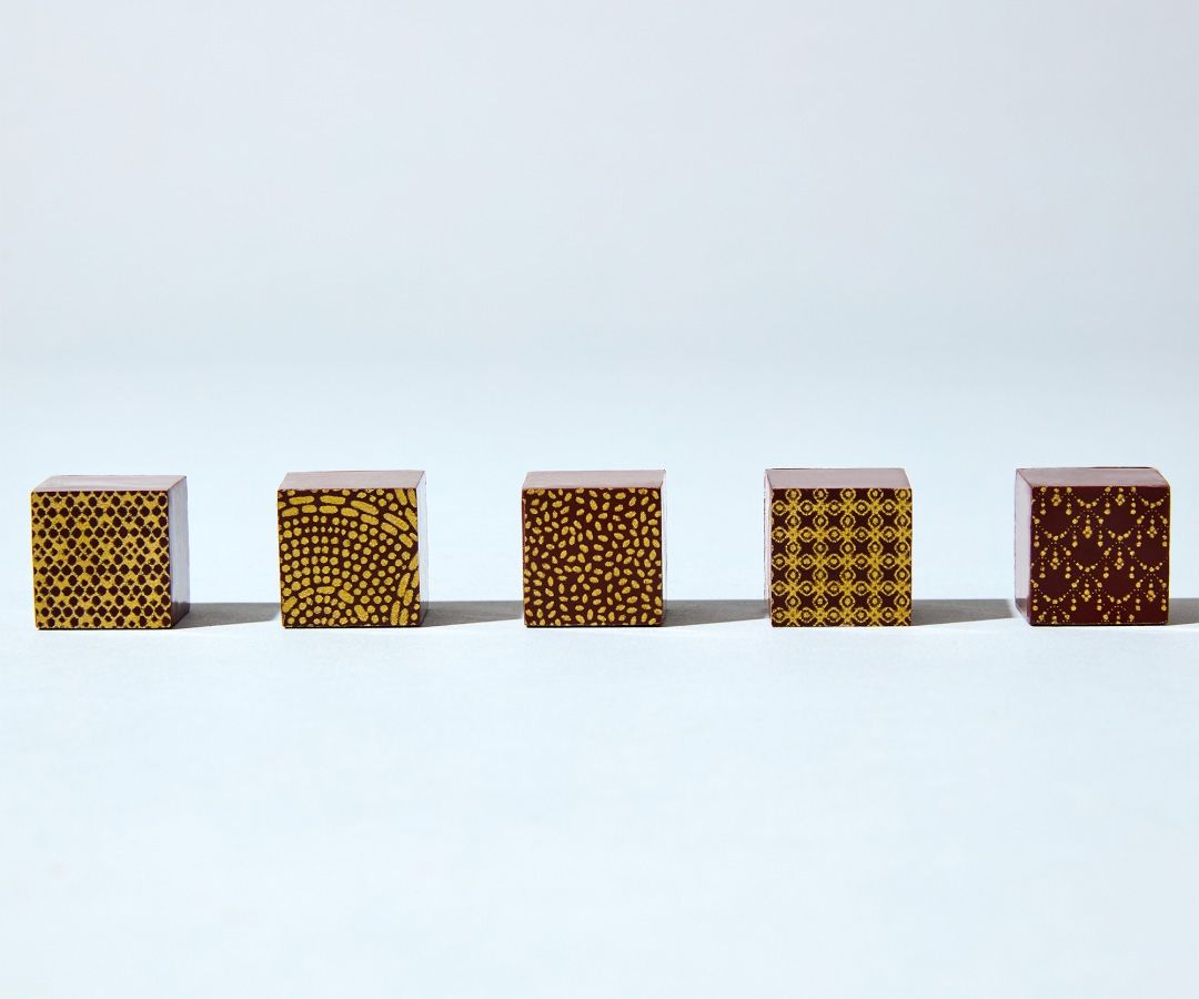 Five small cubes with various patterns arranged in a row.