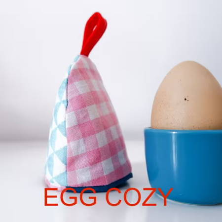 An egg cozie and an hard boiled egg on a table top