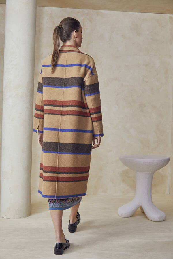 A look book image of a model wearing the Hunter Bell Cambridge Coat Camel Stripe.