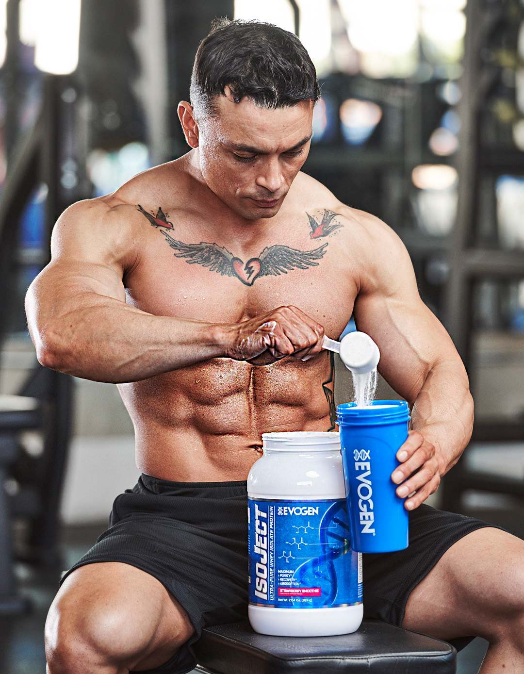 Athlete Frank Bugner scoops IsoJect out of a can into a shaker in the gym