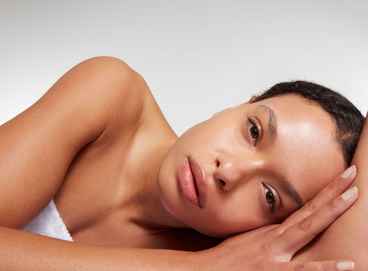 A woman resting her head on her hand, with a serene expression.