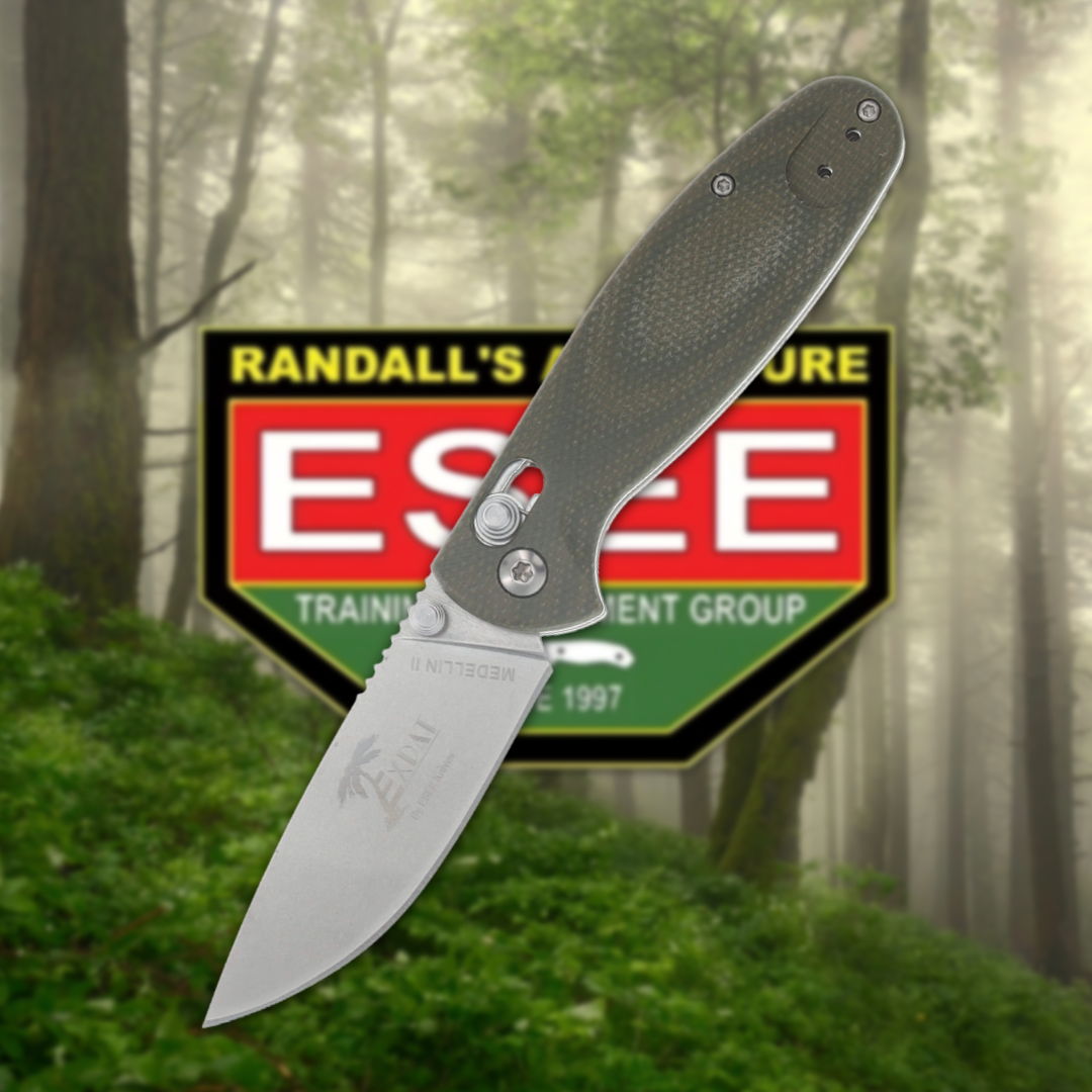 A folding knife in front of a forest backdrop and logo.
