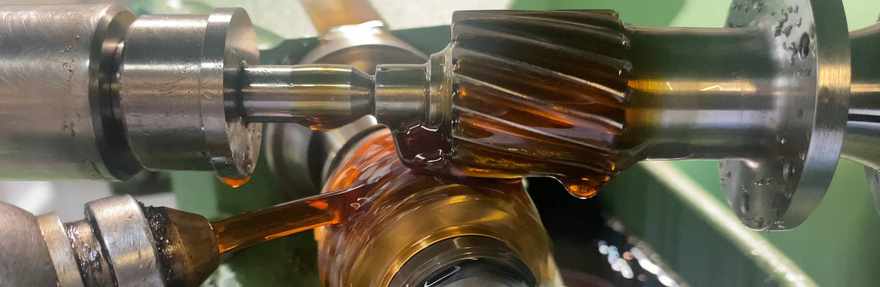 Close-up of mechanical components with lubricant, showcasing gears and metal parts.