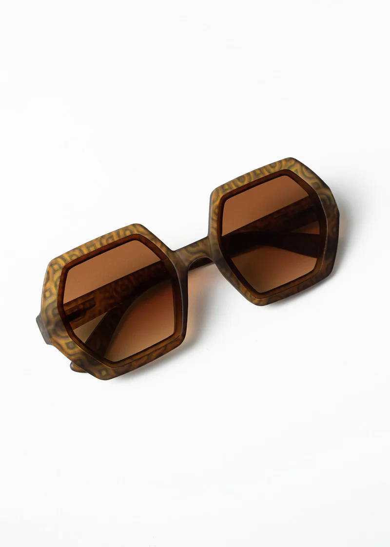 A pair of hexagonal, tortoiseshell oversized sunglasses with brown tinted lenses