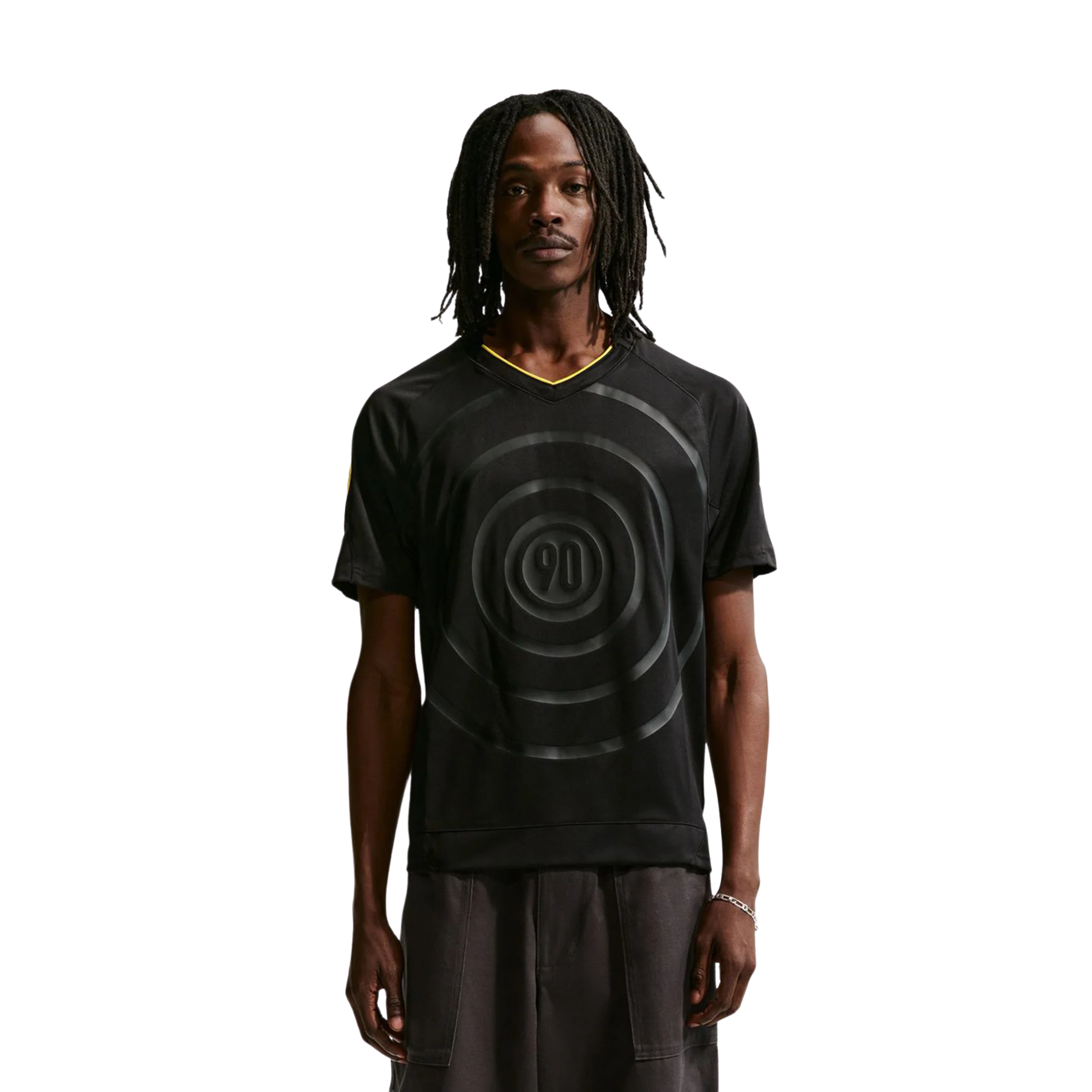 Person wearing a black t-shirt with a circular design, standing against a plain background.