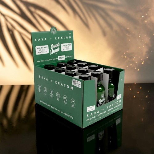 Display of a green box containing various beverage bottles on a reflective surface.
